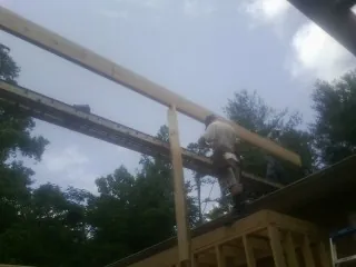 Carpenter setting a ridge beam over a new addition frame — Ice Dam Removal by Roofing Brothers in New Tripoli