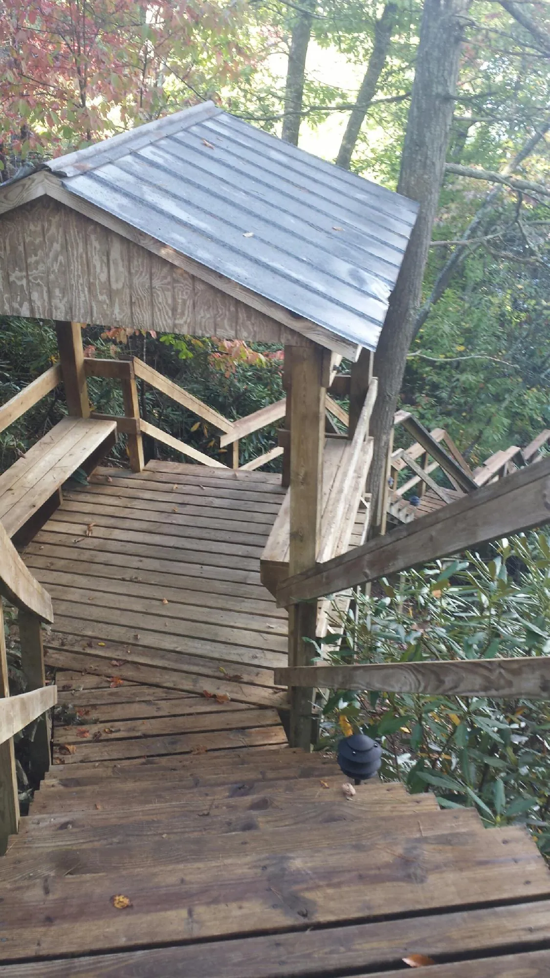Metal roofed shelter over wooden steps on a wooded walkway — Skylight Repair & Installation work by our crew in New Tripoli