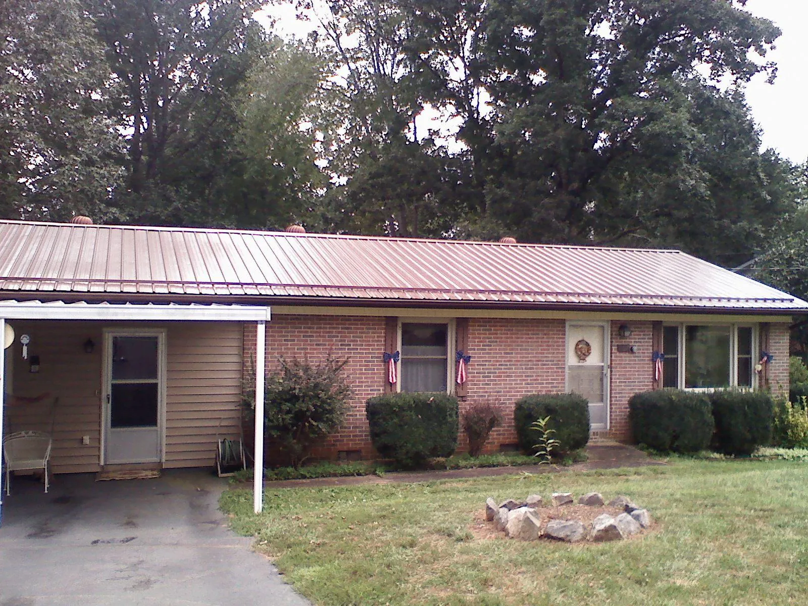 Bronze metal roof and carport on a brick ranch home — Roof Repair work by our crew in New Tripoli